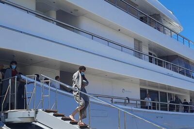 Survivors disembark the yacht in Greece. AP