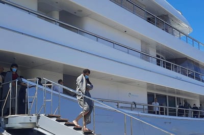 Survivors disembark the yacht in Greece. AP