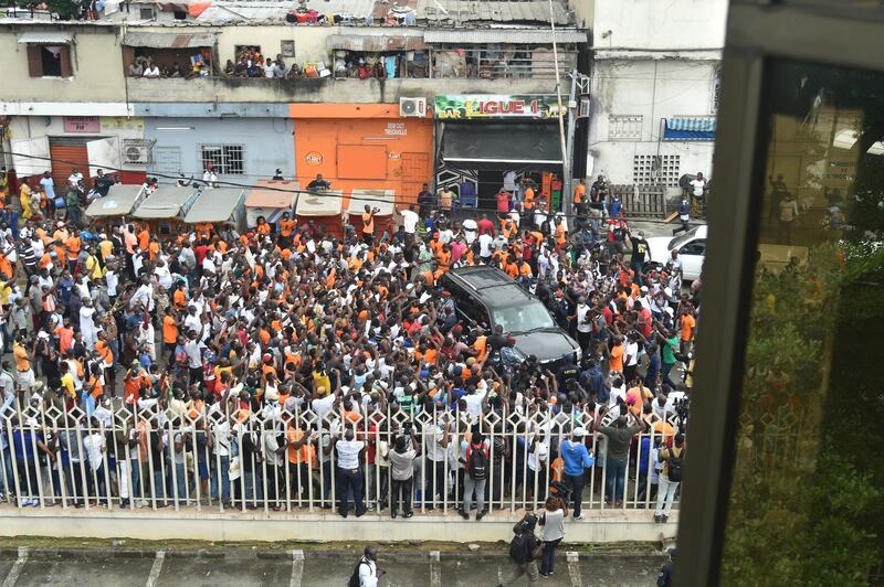 Supporters cheer as they surround the car carrying former Ivorian forward Didier Drogba arriving to submit his application as president of the Ivorian football federation at the FIF headquarter in Treicheville district of Abidjan, on August 1, 2020.

 / AFP / SIA KAMBOU
