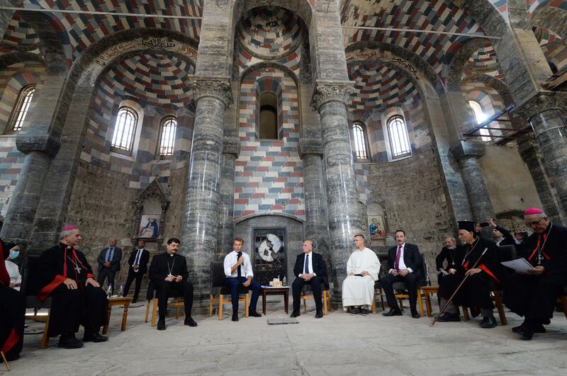 French President Emmanuel Macron (C-L) speaks with priests during a tour of the Our Lady of the Hour Church in Iraq's second city of Mosul, in the northern Nineveh province, on August 29, 2021.  (Photo by AFP)