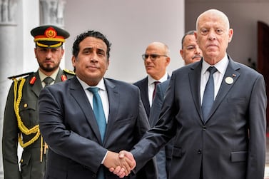 Tunisia's President Kais Saied, right, receives Libyan Presidential Council chairman Mohamed Al Menfi  at Tunis-Carthage International Airport. AFP