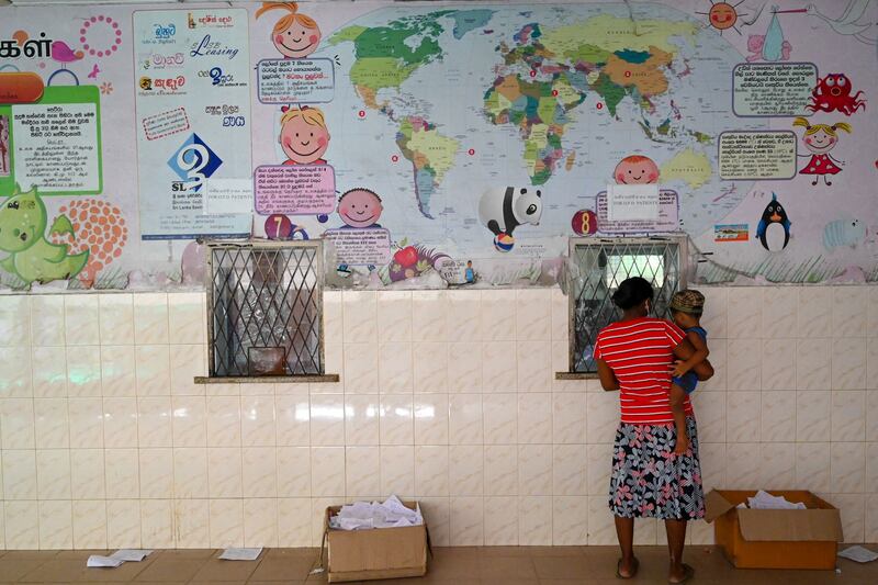 A mother with her child waits for medicines at the pharmacy in Lady Ridgeway Hospital for Children in Colombo. AFP