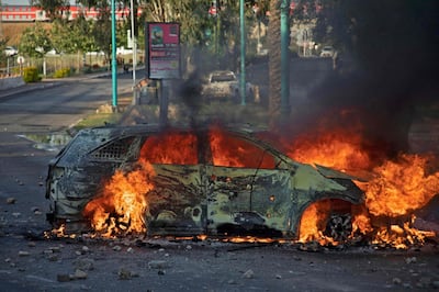 An Israeli police car burns after an Arab Israeli demonstration following the funeral of Mousa Hassouna in the central city of Lod near Tel Aviv, on May 11, 2021.  Hassouna was killed during clashes with Israeli security following an anti-Israel demonstration over tensions in Jerusalem. / AFP / -
