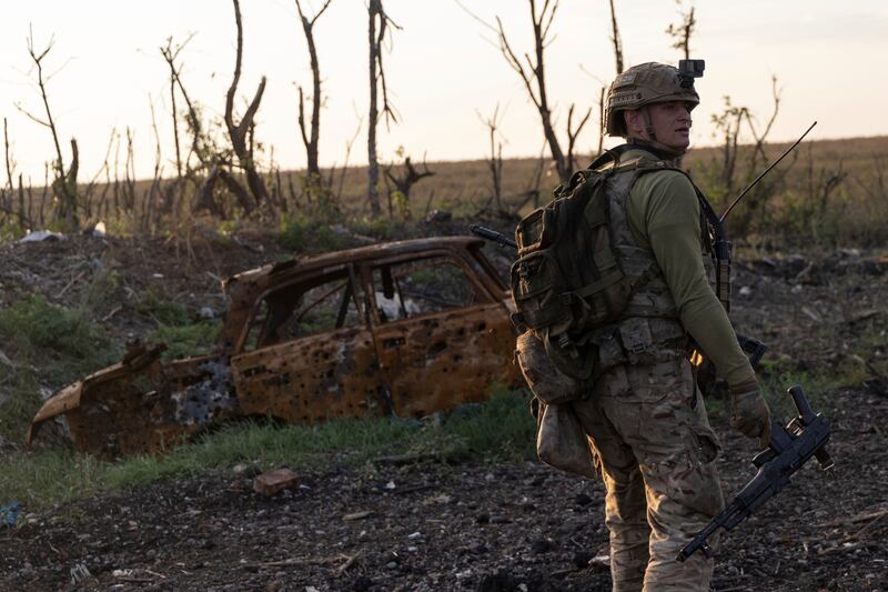 Assault unit commander from 3rd Assault Brigade who goes by the call sign 'Fedia' walks to his position past by a destroyed car at the frontline in Andriivka, Donetsk region, Ukraine, Saturday, September 16, 2023.  The brigade announced Friday they had recaptured the war-ravaged settlement which lies 10 kilometers (6 miles) south of Russian-occupied city of Bakhmut, in the country's embattled east.  (AP Photo / Alex Babenko)