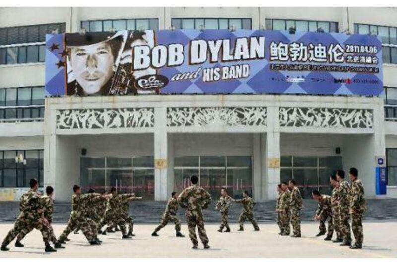 Chinese paramilitary personnel rehearse their morning drills outside the venue for Bob Dylan's first concert in China.