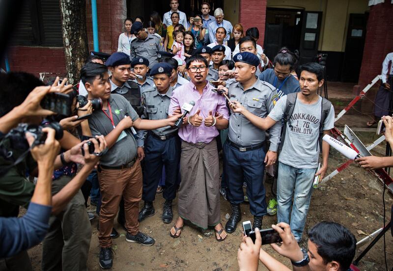 epaselect epa06857123 Detained Reuters journalist Wa Lone (C) talks to media while being escorted by police as he leaves the court after his trial hearing in Yangon, Myanmar, 02 July 2018. Reuters journalists Wa Lone and Kyaw Soe Oo were arrested on the outskirts of Yangon on 12 December 2017 by Myanmar police for allegedly possessing classified police documents.  EPA/LYNN BO BO