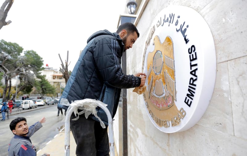 Workers clean the metal plaque on the outside wall of the UAE embassy building during the inauguration ceremony of the reopening of the embassy in Damascus, Syria. EPA