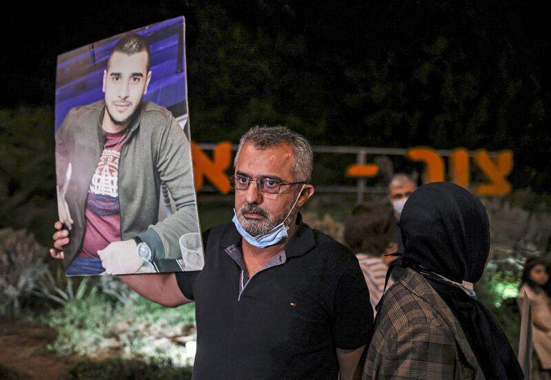 A man holds a picture of a victim during a protest by Arab Israelis against the government's insufficient action towards rising violence levels within the Arab community, outside the home of Public Security Minister Omer Bar-Lev in the northern Israeli town of Kokhav Yair.  AFP
