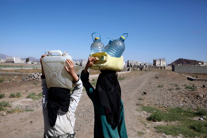 Women carry water on the outskirts of Sanaa, Yemen.  More than 17 million of Yemen's 30-million population lack access to safe water, the UN says. EPA