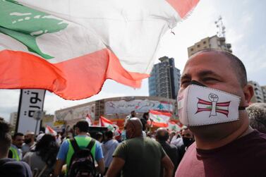 A protester wearing a face mask looks on as he attends a demonstration in Al Nour Square, Tripoli. AFP 