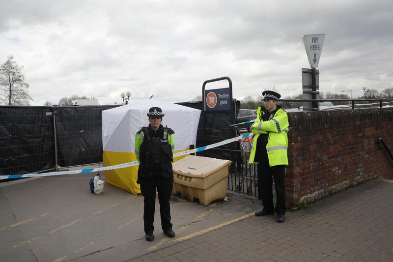 FILE - In this March 13, 2018, file photo, police officers guard a cordon around a police tent covering a supermarket car park pay machine near the spot where former Russian spy Sergei Skripal and his daughter were found critically ill following exposure to the Russian-developed nerve agent Novichok in Salisbury, England. The United States will impose sanctions on Russia for the countryâ€™s use of a nerve agent in an assassination attempt on a former Russian spy and his daughter. The State Department says Aug. 8, sanctions will be imposed on Russia as the country used chemical or biological weapons in violation of international law.(AP Photo/Matt Dunham, File)