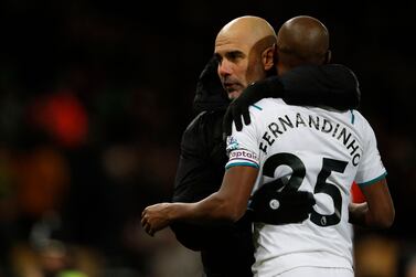 Manchester City's Spanish manager Pep Guardiola embraces Manchester City's Brazilian midfielder Fernandinho on the pitch after the English Premier League football match between Norwich City and Manchester City at Carrow Road Stadium in Norwich, eastern England, on February 12, 2022. - Manchester City won the game 4-0. (Photo by Adrian DENNIS / AFP) / RESTRICTED TO EDITORIAL USE. No use with unauthorized audio, video, data, fixture lists, club/league logos or 'live' services. Online in-match use limited to 120 images. An additional 40 images may be used in extra time. No video emulation. Social media in-match use limited to 120 images. An additional 40 images may be used in extra time. No use in betting publications, games or single club/league/player publications. / 