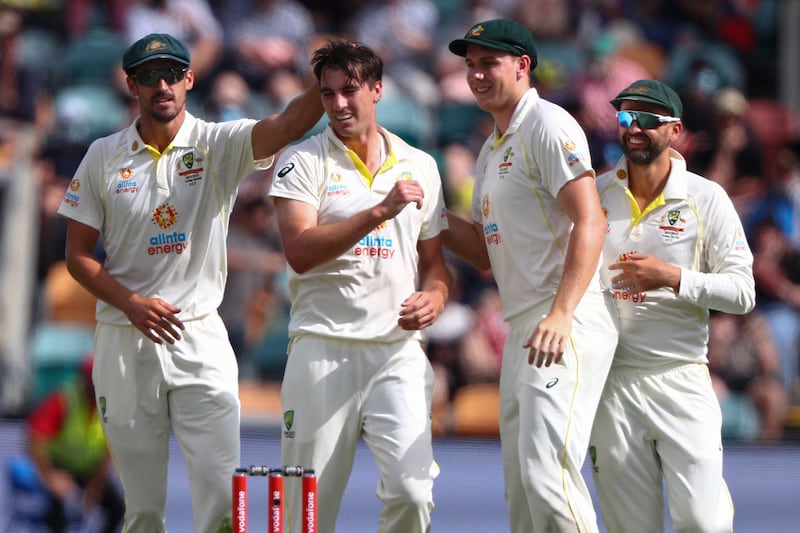 Australia's Pat Cummins celebrates with teammates after taking the wicket of England opener Zak Crawley for 18. AP