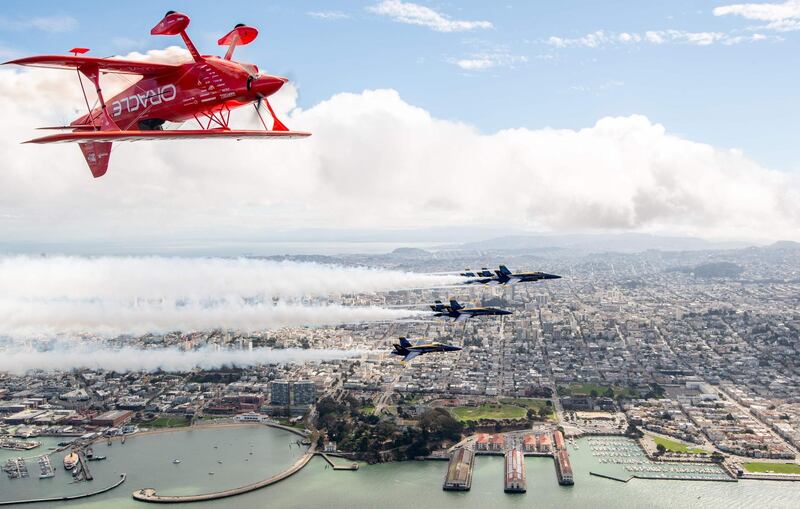 Team Oracle aerobatics pilot Sean Tucker flies above the US Navy Blue Angels over San Francisco. AFP