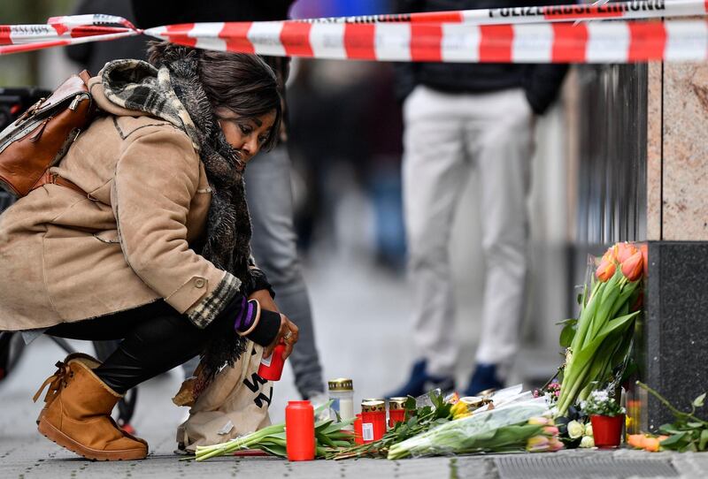 A woman sets a candle near the hookah bar scene where several people were killed late Wednesday in Hanau, Germany.  A 43-year-old German man shot and killed several people at different locations in a Frankfurt suburb overnight in attacks that appear to have been motivated by far-right beliefs, officials said Thursday. AP Photo