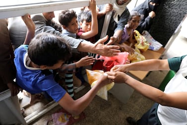 People crowd to get food rations from a charity kitchen in Sanaa. Reuters 