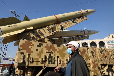 A cleric walks past missiles displayed in a missile capabilities exhibition by the paramilitary Revolutionary Guard a day prior to second anniversary of Iran's missile strike on U. S.  bases in Iraq in retaliation for the U. S.  drone strike that killed top Iranian general Qassem Soleimani in Baghdad, at Imam Khomeini grand mosque, in Tehran, Iran, Friday, Jan.  7, 2022.  (AP Photo / Vahid Salemi)