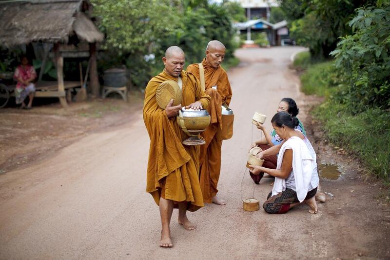 Buddhist monks receive rice from women early morning in a village outside Nong Khai, Thailand. Jorge Silva / Reuters