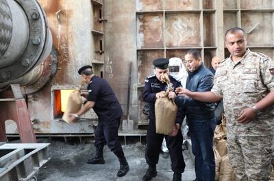 Jordanian security personnel placing bags of drugs in a furnace to destroy them. Jordanian News Agency