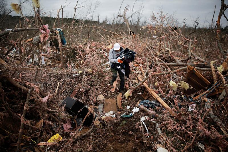 Dax Leandro salvages clothing from the wreckage of his friend's home after back-to-back tornadoes in Beauregard, Alabama. Reuters