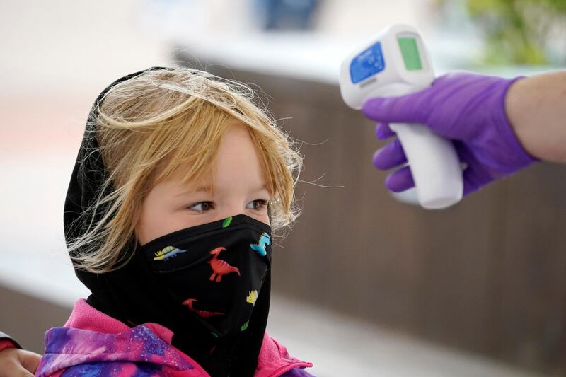 ALTON, ENGLAND - JULY 04: A child wears a mask as she has her temperature checked at the entrance to Alton Towers on July 4, 2020 in Alton, England. The popular theme park reopens with coronavirus safety measures in place today, after the British government eased their coronavirus restrictions to allow some leisure and hospitality businesses to reopen after more than 3 months in lockdown.  (Photo by Christopher Furlong/Getty Images)