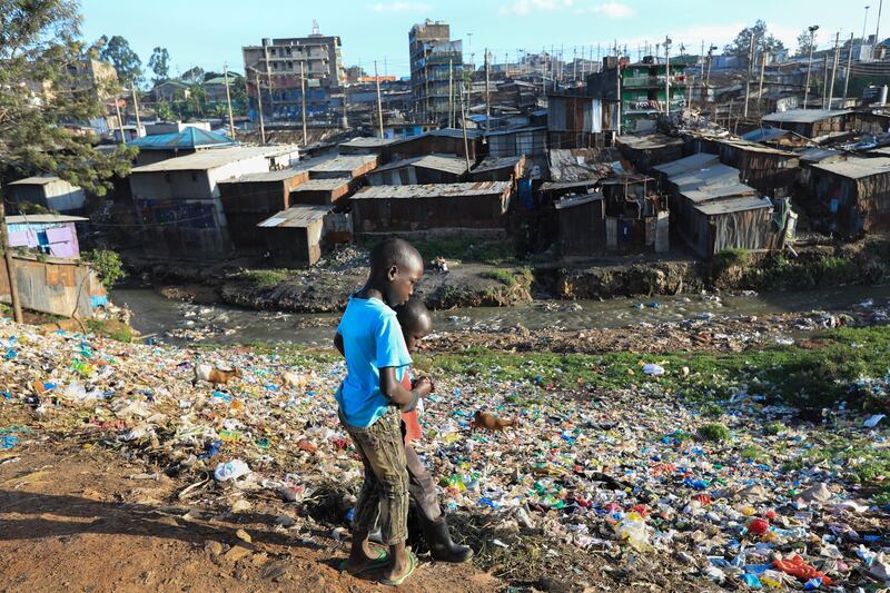 Young boys walk through a pile of garbage looking for plastic waste in the Mathare slum in Nairobi, Kenya.  EPA