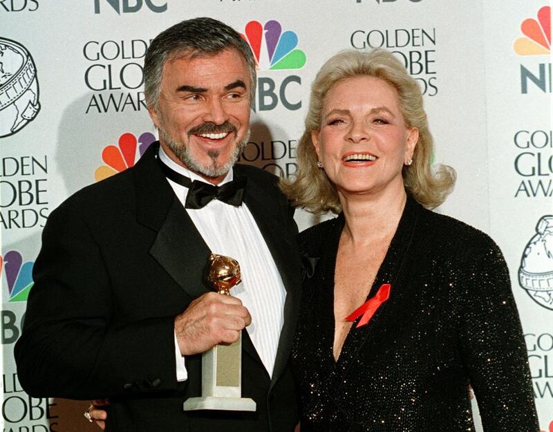 Burt Reynolds and Lauren Bacall pose for photographers as Reynolds holds his Golden Globe that he won for best supporting actor in a motion picture for the film Boogie Nights, at the 55th annual Golden Globe Awards in Beverly Hills, in January 18, 1999. Reuters