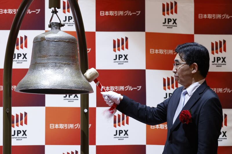 Hiroyuki Nagai, president and chief executive officer of Rakuten Bank, strikes the trading bell during the company's listing ceremony at the Tokyo Stock Exchange. Bloomberg