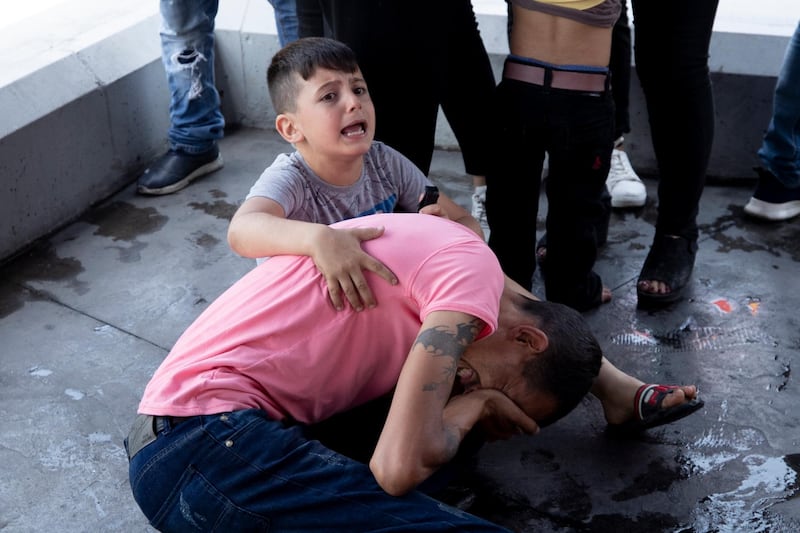 A boy screams for help after his father was injured in the clashes north of Beirut. AP Photo