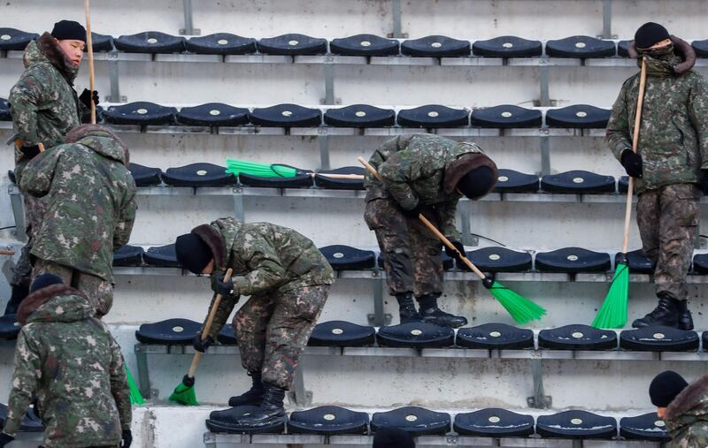 Korean soldiers clear ice from the stands at the Alpensia Ski Jumping Center ahead of the Pyeongchang 2018 Winter Olympic Games. Odd Andersen / AFP