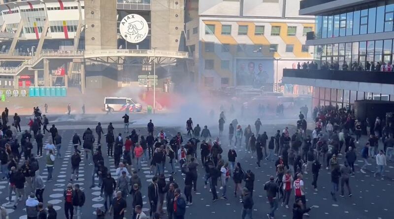 Police officers use teargas to disperse football fans rioting Johan Cruyff Arena. EPA