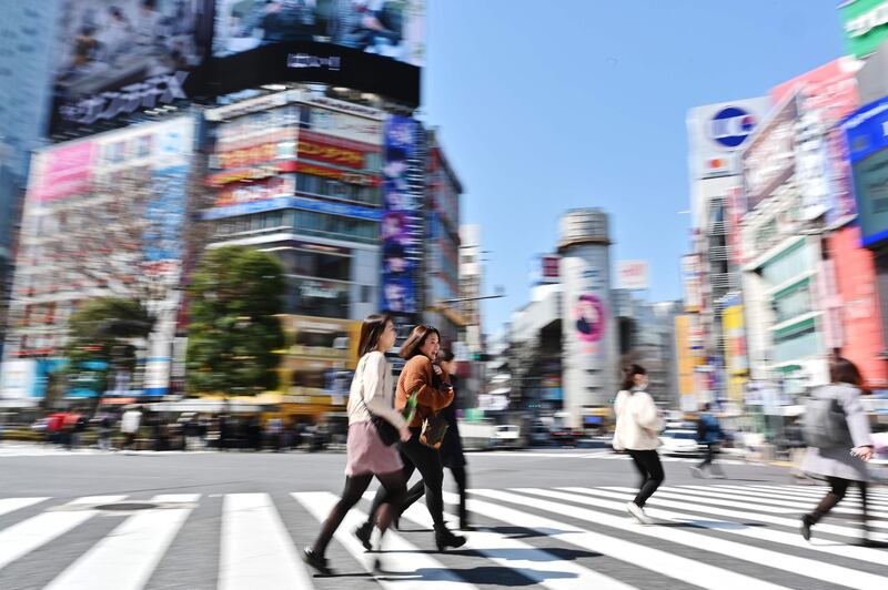 Women walk across the landmark pedestrian crossing in Tokyo's Shibuya district. AFP