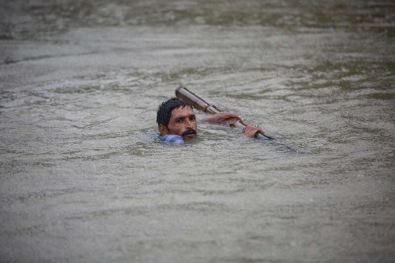 A man tries to cross flood water at Topa village in Saptari district, Nepal. Narendra Shrestha / EPA