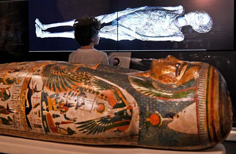 A young boy looks at a three-dimensional image of a CT scan of an Egyptian mummy as the the hidden secrets of Egyptian mummies up to 3,000 years old have been virtually unwrapped and reconstructed for the first time using cutting-edge scanning technology in a joint British-Australian exhibition in Sydney on December 8, 2016. AFP / WILLIAM WEST

