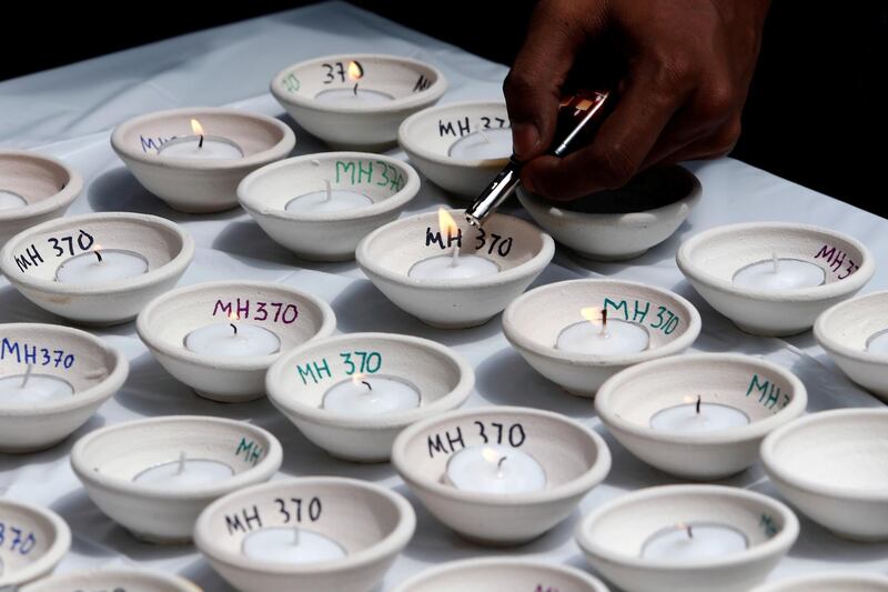 A man lights candles during the fourth annual remembrance event for the missing Malaysia Airlines flight MH370, in Kuala Lumpur, Malaysia March 3, 2018. REUTERS/Lai Seng Sin