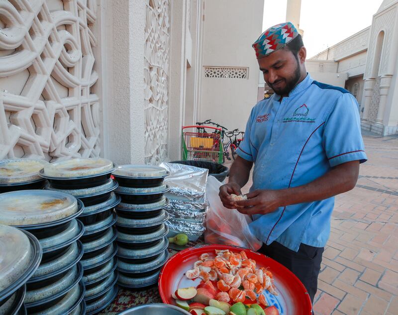 A volunteer prepares plates of fruit for those about to break their fast. Victor Besa / The National