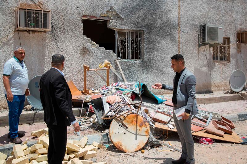 Iraqis inspect the damage at a drilling facility that was hit by a Katyusha rocket in the Burjesiya area, north of the Iraqi city of Basra.  AFP