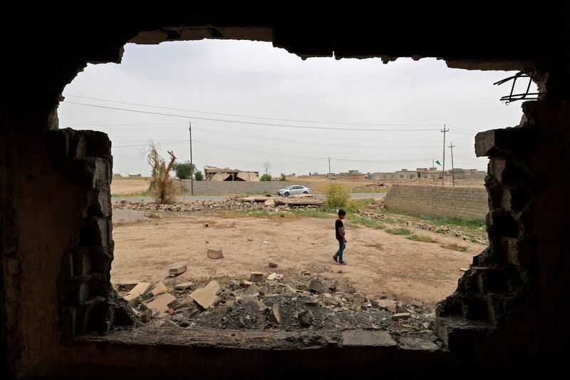 A boy is seen through a hole in the wall of a house in the war-ravaged village of Habash, 180 kilometres north of Iraq's capital Baghdad.  All photos by AFP