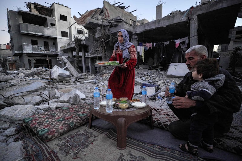 A family break fast amid the ruins of their home in Deir al-Balah, the central Gaza Strip. AFP