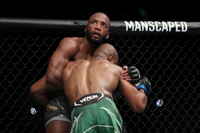 Kamaru Usman has Leon Edwards up against the cage during their welterweight title bout at UFC 286. PA