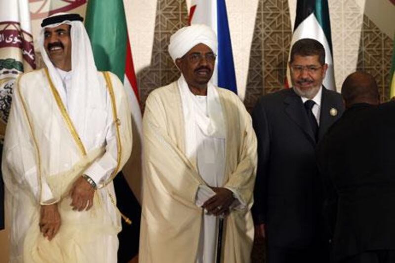 Qatar's emir, Sheikh Hamad bin Khalifa Al Thani, left, the Sudanese president Omar Al Bashir, centre, and Mohamed Morsi, Egypt's president, at the Arab League summit in Doha on Tuesday. Karim Sahib / AFP