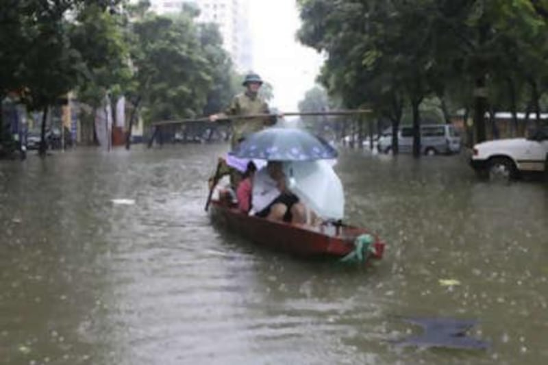 Residents travel by boat along a flooded street in Hanoi on Nov 1 2008. Vietnamese authorities warned of more flash floods in the north of the country.