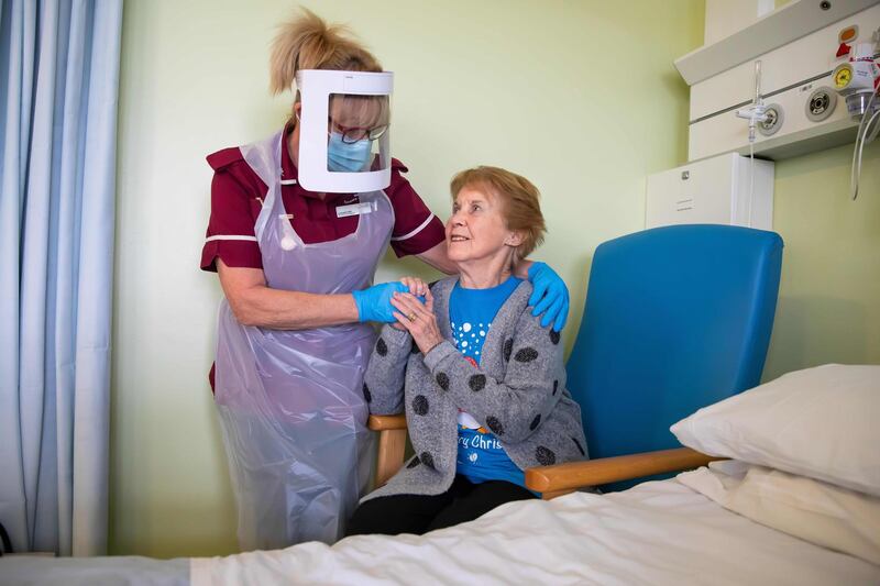 Margaret Keenan, 90, who was the first patient in the United Kingdom to receive the Pfizer-BioNtech Covid-19 vaccine, reacts as she talks with Healthcare assistant Lorraine Hill, while preparing to leave University Hospital Coventry. AFP
