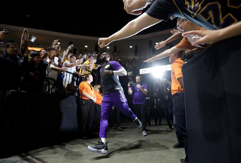 Los Angeles Lakers forward LeBron James runs past fans on his way to the court before an NBA preseason basketball game in San Diego. Gregory Bull/AP Photo