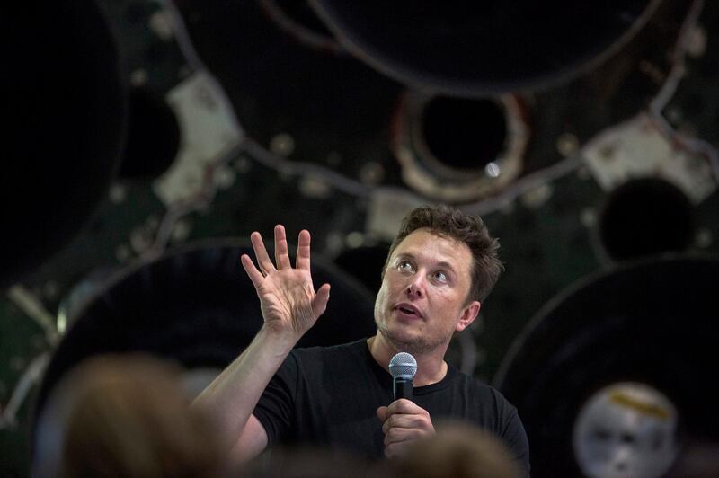 Elon Musk speaks near a Falcon 9 rocket during his announcement that Japanese billionaire Yusaku Maezawa will be the first private passenger who will fly around the Moon aboard the SpaceX BFR launch vehicle, at the SpaceX headquarters and rocket factory on September 17, 2018 in Hawthorne, California.  Japanese billionaire businessman, online fashion tycoon and art collector Yusaku Maezawa was revealed as the first tourist who will fly on a SpaceX rocket around the Moon. / AFP / DAVID MCNEW
