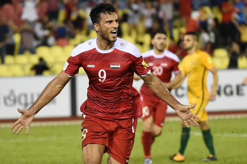 Omar Al Somah of Syria (L) celebrates a penalty goal against Australia during the 2018 World Cup qualifying football match between Syria and Australia at the Hang Jebat Stadium in Malacca on October 5, 2017. / AFP PHOTO / MOHD RASFAN