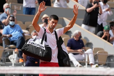 Serbia's Novak Djokovic waves to the crowd after Italy's Lorenzo Musetti retired from the match in their fourth round match on day 9, of the French Open tennis tournament at Roland Garros in Paris, France, Monday, June 7, 2021. (AP Photo/Michel Euler)