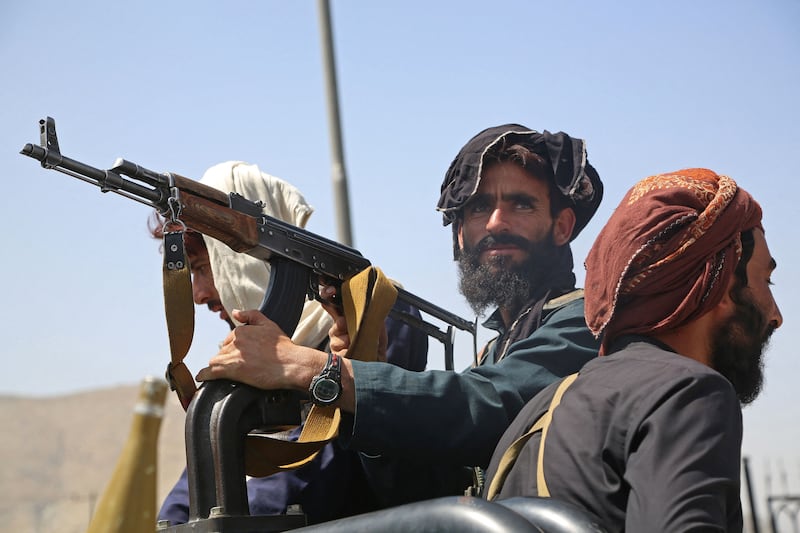 Taliban fighters stand guard in a vehicle along the roadside in Kabul on August 16, 2021. AFP