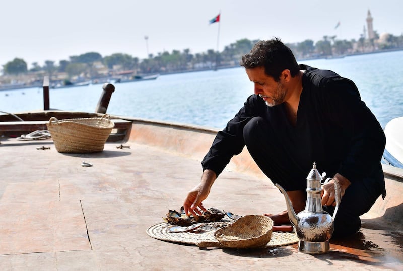 Emirati Abdullah al-Suwaidi open oysters to look for pearls at the Suwaidi's pearl farm, off the coast of al-Rams in the northern emirate of Ras al-Khaimah, on October 31, 2019. Suwaidi's project, one of a handful of operations in the United Arab Emirates, comes against a backdrop of increasing awareness of cultural traditions, such as falconry and camel racing, and efforts to promote and preserve them. Last month, Abu Dhabi authorities announced that the world's oldest natural pearl, found just off the capital at Marawah Island, would be displayed for the first time at the Louvre Abu Dhabi, the local outpost of the famous Paris museum.
 / AFP / GIUSEPPE CACACE
