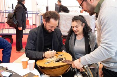 Iraqi musician Naseer Shamma signs an oud to a fan after his session at the Frankfurt Book Fair on October 16, 2019. Courtesy Kalima